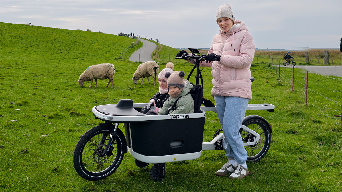 Familie nutzt das TARRAN-Lastenrad auf einer grünen Wiese