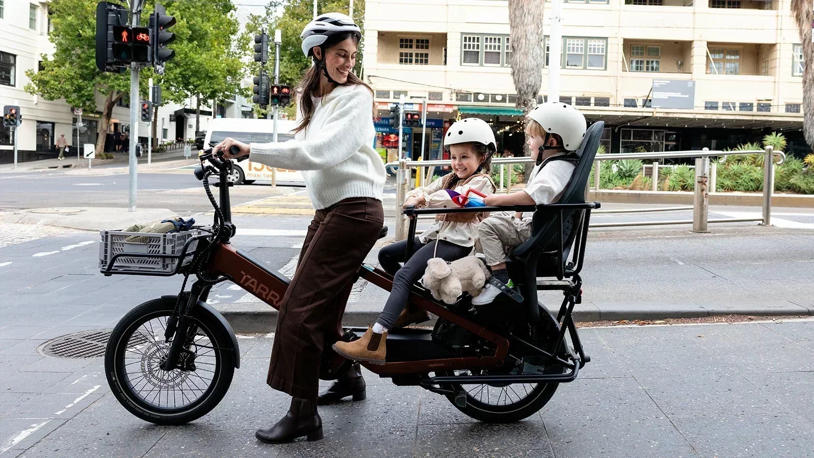 Parent with two children on a TARRAN electric cargo bike in the city