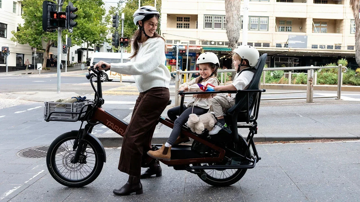 Parent with two children on a TARRAN electric cargo bike in the city